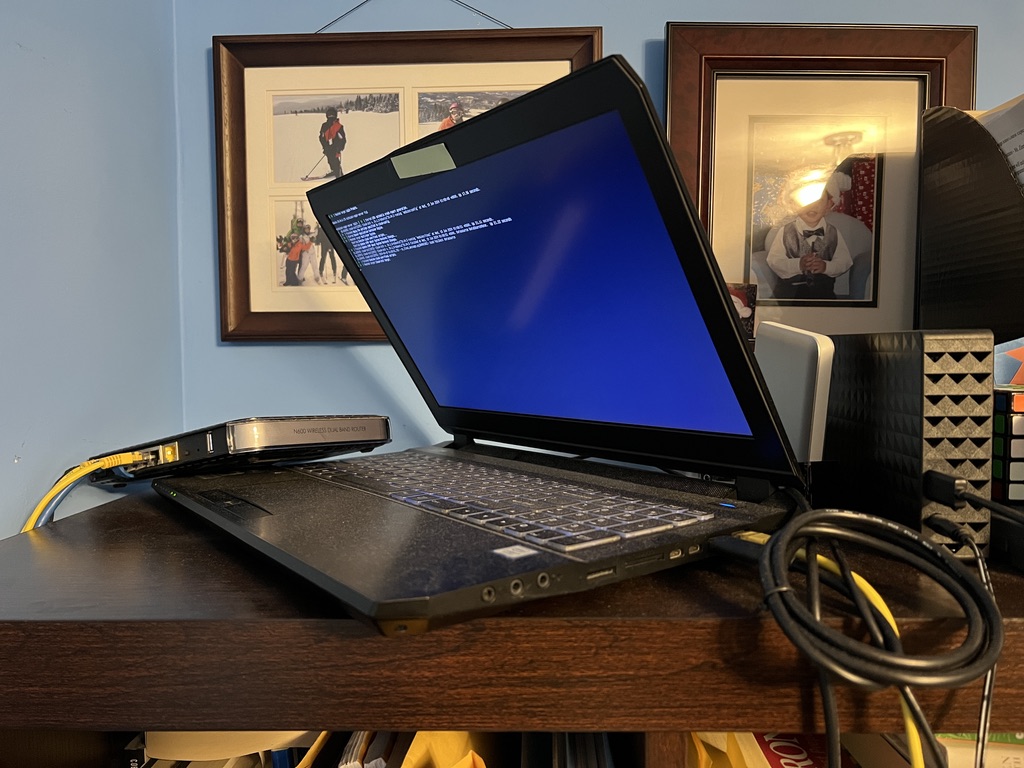 Laptop on shelf with external hard drives plugged in